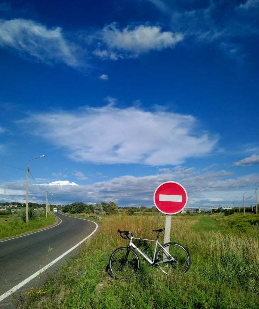 red and white stop sign on green grass field under blue sky during daytime